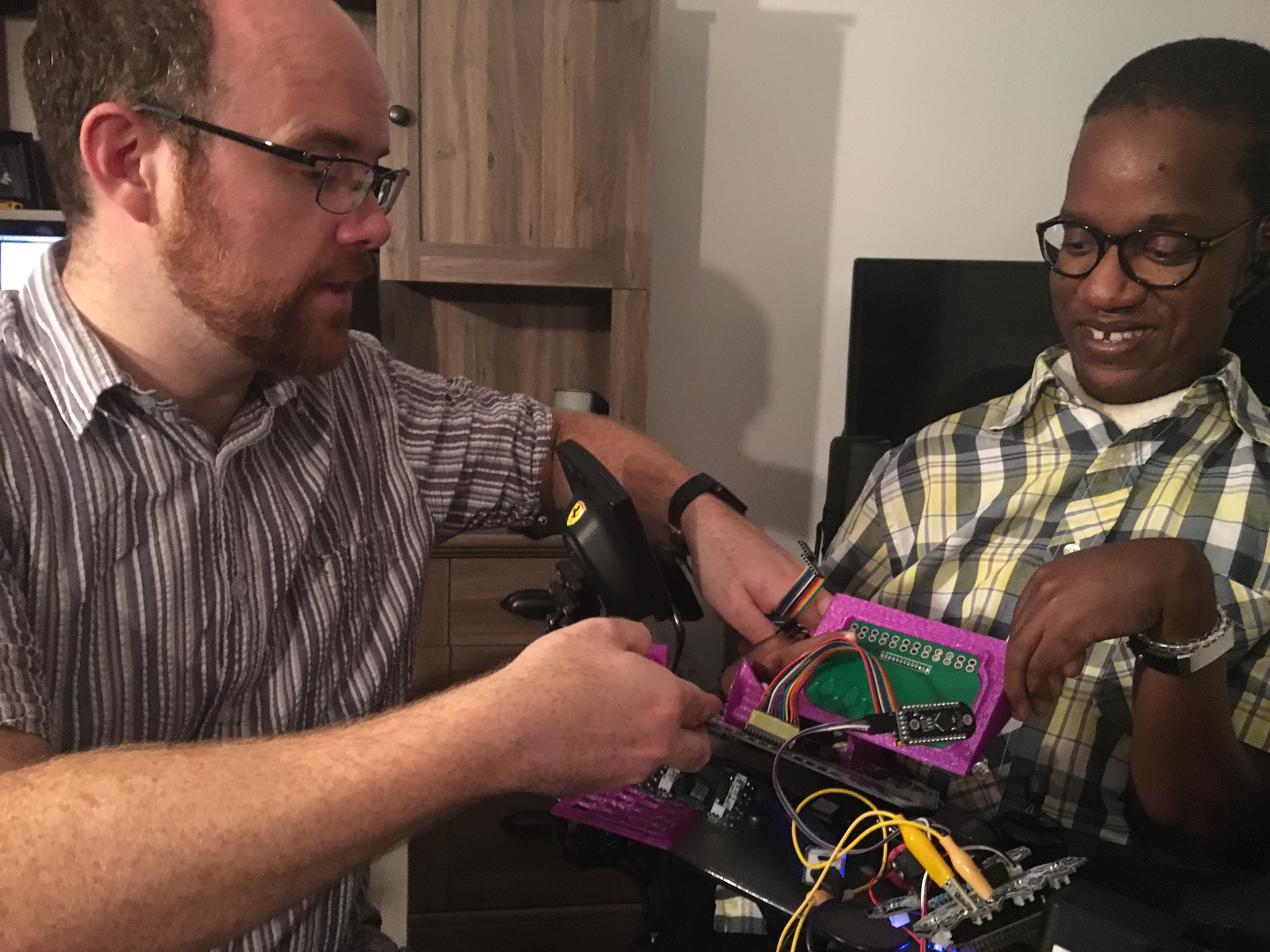 Charles and Gift holding a miniature keyboard made of 3D printed parts and a custom circuit board.